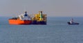 Loading anchored oil supertanker via a ship-to-ship oil transfer