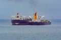 Loading anchored oil supertanker via a ship-to-ship oil transfer