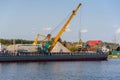 Loading barge with sand and rubble on a small berth. Freight transport logistics.