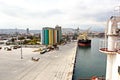 Loading cargo of cement clinker in bulk carrier by ships cranes in the port of Izmir, Turkey. Royalty Free Stock Photo