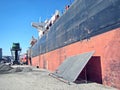 Loading cargo of cement clinker in bulk carrier by ships cranes in the port of Izmir, Turkey. Royalty Free Stock Photo