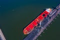 Loading coal anthracite mining in port on cargo tanker ship with crane bucket of train. Aerial top view