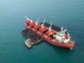 Loading coal on bulk vessel ship in offshore cargo port. Aerial top view.