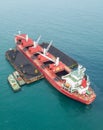 Loading coal on bulk vessel ship in offshore cargo port. Aerial top view.