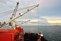 Loading coal from cargo barges onto a bulk carrier using ship cranes and grabs at the port of Samarinda, Indonesia. Royalty Free Stock Photo