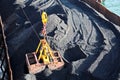 Loading coal from cargo barges onto a bulk carrier using ship cranes and grabs at the port of Samarinda, Indonesia. Royalty Free Stock Photo