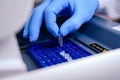 Loading a DNA tube into a PCR polymerase chain reaction thermocycler machine in a bioscience laboratory. Concept of science,