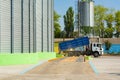 Loading grain by trucks onto the elevator into metal containers Royalty Free Stock Photo