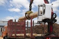 Loading logs onto a logging truck. Portable crane on a logging truck