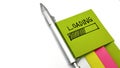 Loading message on green sticky note, with silver pen and colorful note pads, isolated on white background, Royalty Free Stock Photo