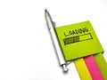 Loading message on green sticky note, with silver pen and colorful note pads, isolated on white background, Royalty Free Stock Photo