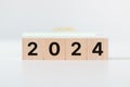 2024 loading progress bar inscription on wooden cube blocks on desk and wall white background. Royalty Free Stock Photo