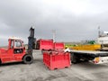 Loading red containers full of beft waste onto a truck using a forklift. The process of transporting and storing drill cuttings in Royalty Free Stock Photo
