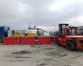 Loading red containers full of beft waste onto a truck using a forklift. The process of transporting and storing drill cuttings in Royalty Free Stock Photo