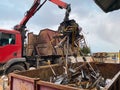 Loading scrap metal into a truck. Crane grabber loading metal rusty scrap in the dock Royalty Free Stock Photo