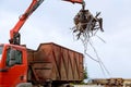 Loading scrap metal into a truck. Crane grabber loading metal rusty scrap in the dock Royalty Free Stock Photo