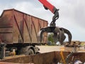 Loading scrap metal into a truck. Crane grabber loading metal rusty scrap in the dock Royalty Free Stock Photo