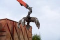 Loading scrap metal into a truck. Crane grabber loading metal rusty scrap in the dock Royalty Free Stock Photo