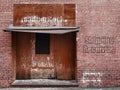 Loading shipping receiving dock door faded text brick wall alley closed weathered industrial entrance