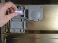 Loading the soluble-coated tablets in the dishwasher. Powder, dishwashing detergent and rinse aid. Washing dishes in the kitchen