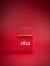 Loading to Merry Christmas and happy new year 2023 background. Loading, text appears on small red desk calendar.