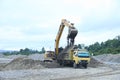 Loading truck with sand by excavator