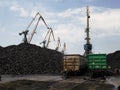 Loading unloading of coal in the port into freight trains using large port cranes Royalty Free Stock Photo