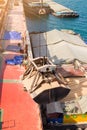 Loading wheat on cargo ship with crane and bucket. Shipment from a merchant ship to a small ship. Grapple crane fill wheat into