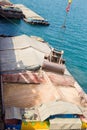 Loading wheat on cargo ship with crane and bucket. Shipment from a merchant ship to a small ship. Grapple crane fill wheat into