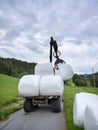 loading white grass rolls on country road in norway Royalty Free Stock Photo