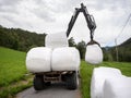 loading white grass rolls on country road in norway Royalty Free Stock Photo