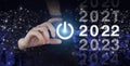 Loading year 2021 to 2022. Start concept. Hand hold digital hologram 2022 sign on city dark blurred background. Concept Start New