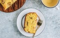 Loaf of banana bread on a wooden cutting board with cup of tea on light gray table Royalty Free Stock Photo