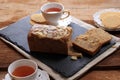 Loaf Banana Nut Sweet Bread Sliced on a Slate Plate, Served with Tea