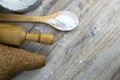 A loaf of bread along with rocking for the dough in a craft bag stand on a wooden table, next to it is satiated with flour. Top