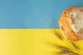 Loaf of bread and ears of wheat on a yellow and blue background Royalty Free Stock Photo