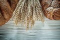 Loaf of bread rye ears on white wooden board Royalty Free Stock Photo