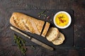 Loaf of bread with spicy olive oil and old rusty table-knife Royalty Free Stock Photo