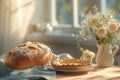 loaf of bread on the table, pies on a plate nearby and flowers by the blur window on a sunny day Royalty Free Stock Photo