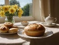 loaf of bread on the table, pies on a plate nearby and flowers by the blur window on a sunny day Royalty Free Stock Photo