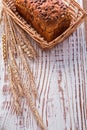 Loaf of bread in wicker basket golden wheat ears