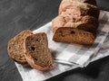 Loaf dark buckwheat bread on white textile napkin black table background. Fresh delicious homemade healthy bake. Bakery Royalty Free Stock Photo