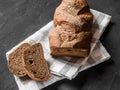 Loaf dark buckwheat bread on white textile napkin black table background. Fresh delicious homemade healthy bake. Bakery Royalty Free Stock Photo