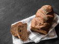 Loaf dark buckwheat bread on white textile napkin black table background. Fresh delicious homemade healthy bake. Bakery Royalty Free Stock Photo