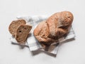 Loaf dark buckwheat bread on white textile napkin white table background. Fresh delicious homemade healthy bake. Bakery Royalty Free Stock Photo