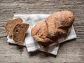 Loaf dark buckwheat bread on white textile napkin wooden table background. Fresh delicious homemade healthy bake. Bakery Royalty Free Stock Photo