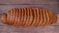 Loaf of the dark rye bread cut into pieces on a table Royalty Free Stock Photo