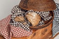 Loaf of fresh homemade french bread in bread rattan basket with kitchen linen check towels on solid wood stump. Royalty Free Stock Photo
