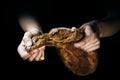 A loaf of freshly baked bread in the hands of a baker