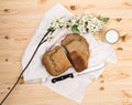 Loaf of freshly baked homemade rye bread, sliced with a knife on a white towel and milk on a wooden table Royalty Free Stock Photo